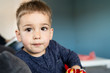 © Miljan Živković - Portrait of a little small boy eating unhealthy snacks corn peanut flips at home