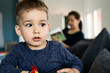 © Miljan Živković - Portrait of a little small boy eating unhealthy snacks corn peanut flips at home