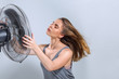 © Svetlana Radayeva - Young woman enjoying cool wind from electric fan