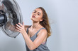 © Svetlana Radayeva - Young woman enjoying cool wind from electric fan