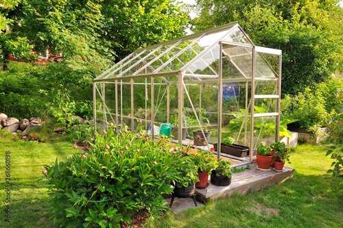 Photographie A garden center greenhouse with a colorful display of potted plants and flowers