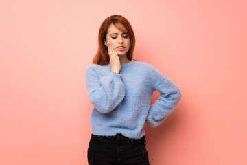 Wall Mural - Young redhead woman over pink background with toothache