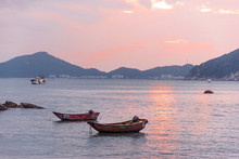 Wooden Red Boats Floating On The Sea At Sunset