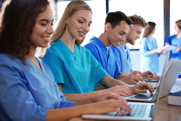 Wall Mural - Group of smart medical students with gadgets in college