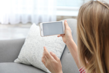 Poster - Young woman using video chat on smartphone in living room, closeup. Space for design