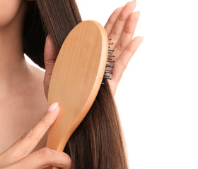 Wall Mural - Woman with hair brush on white background, closeup