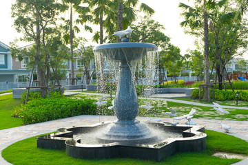 Old rustic stone fountain in garden.