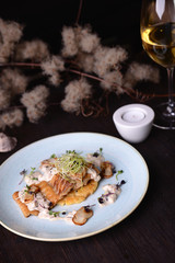 Canvas Print - fried fish fillet with a sauce on the background of a glass of wine