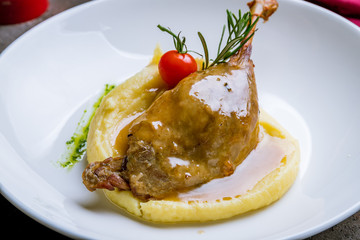 Sticker - Duck leg confit on white plate on dark concrete