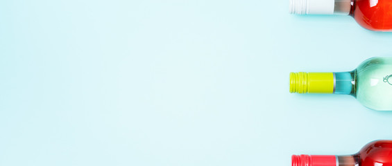 Wall Mural - Colorful bottle caps of white and rose wine bottles on turquoise background. Minimal abstract colorful layout concept of summer time alcohol beverage. Long wide banner.