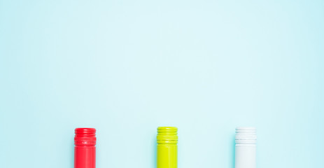 Wall Mural - Colorful bottle caps of white and rose wine bottles on turquoise background. Minimal abstract colorful layout concept of summer time alcohol beverage. Long wide banner.