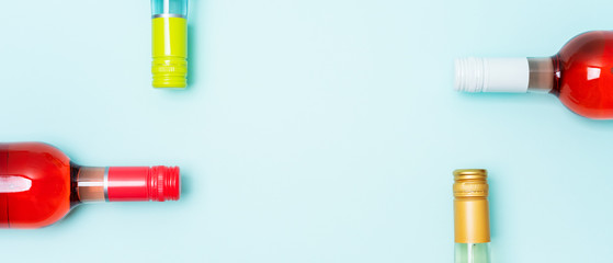 Wall Mural - Colorful bottle caps of white and rose wine bottles on turquoise background. Minimal abstract colorful layout concept of summer time alcohol beverage. Long wide banner.