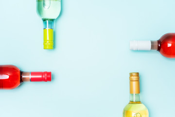 Wall Mural - Screw bottle foil caps in different bright colors of white and rose wine bottles on blue background with copy space. Minimal abstract colorful mockup concept of alcohol beverage. Flat lay.