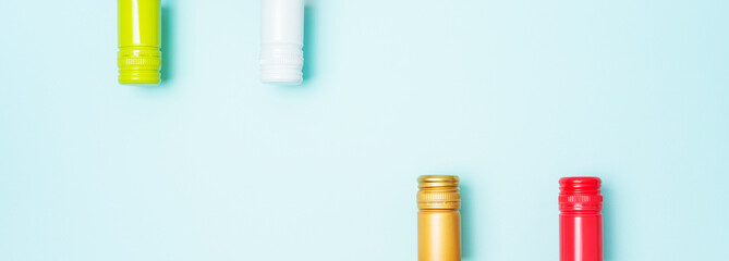 Wall Mural - Colorful bottle caps of white and rose wine bottles on turquoise background. Minimal abstract colorful layout concept of summer time alcohol beverage. Long wide banner.