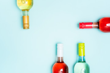 Wall Mural - Mockup frame of bottle foil caps in different bright colors of white and rose wine bottles on blue background with copy space. Minimal abstract colorful mockup concept of alcohol beverage. Flat lay.