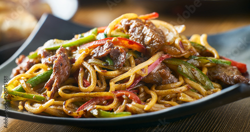 Fotografía asian stir fried noodles with beef peppers and onions panorama