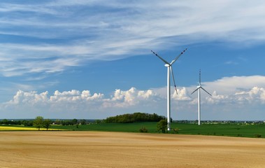 Elektrownia wiatrowa w polu na tle pięknych kłębiastych chmur