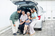 © Creativa Images - Cute little girl sitting with her family in car trunk