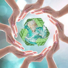 Hands surrounding green planet protected by recycle sign leaf on blurred bokeh .Elements of this image furnished by NASA.