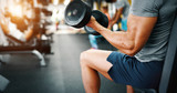 Fototapeta  - Determined handsome and young male working out in gym