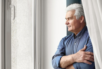 Poster - Portrait of handsome senior man near window at home