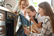 © Pixel-Shot - Little girl with her mother and grandmother cooking cookies in kitchen at home