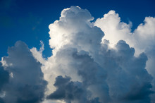 Abstract View Of Billowing Thunderstorm Clouds Building Against Bright Blue Summer Sky