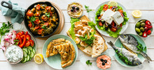 Selection Of Traditional Greek Food - Salad, Meze, Pie, Fish, Tzatziki, Dolma On Wood Background, Top View