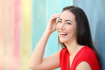 Wall Mural - Joyful woman in red laughing looking at camera