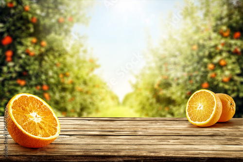 Dekoracja na wymiar  swieze-pomaranczowe-owoce-na-biurku-i-letni-krajobraz-pomaranczowy-ogrod-ze-swiatlem-slonecznym