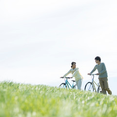 Wall Mural - 草原で自転車を押すカップル