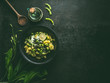 © VICUSCHKA - Potatoes and green asparagus salad with edamame soybeans and ramson yogurt dressing in black bowl on dark rustic kitchen table background, top view with copy space. Healthy seasonal food concept
