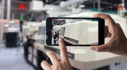 Sticker - Augmented reality concept. AR. Industrial 4.0 , Hand of engineer holding mobile smart phone using virtual AR to check the work of electric machine on smart factory background.