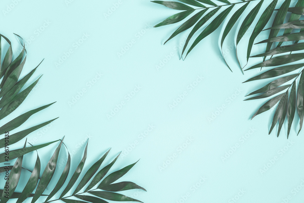Summer composition. Palm leaves on pastel blue background. Summer concept. Flat lay, top view, copy space - obrazy, fototapety, plakaty 