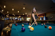 © RomanR - Young and beautiful woman in pub playing billiard