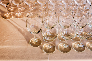 Wall Mural - many empty champagne glasses close up. glass goblets on the white table. Empty crystal wineglass. glass goblet on a high leg.