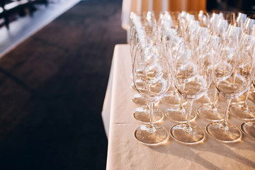 Wall Mural - many empty champagne glasses close up. glass goblets on the white table. Empty crystal wine glass. glass goblet on a high leg.