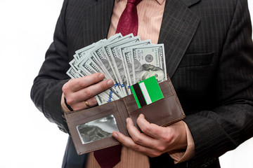 Man in suit holding wallet with dollar banknotes and credit card