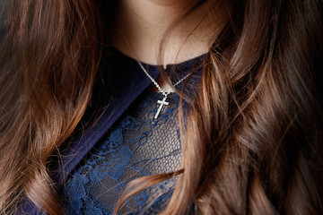 Mouth and chin of girl putting on a crucifix