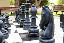 Сhessboard With Large Plastic Figures. Large Outdoor Chess In The Public Area, Large Street Chess In The Park