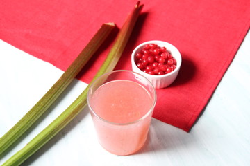 Wall Mural - Glass of jelly  made of rhubarb and  currant on white and red background