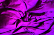 Purple fabric. Crumpled bedding. Background. Texture. Soft focus.