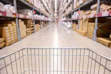 Shopping cart view in Warehouse aisle with product shelves abstract blur defocused background