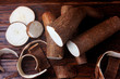 fresh cassava and peels and slices on rustic wooden table