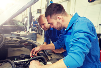 Wall Mural - auto service, repair, maintenance and people concept - mechanic men with wrench repairing car at workshop