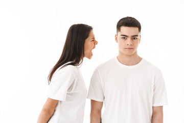 Angry young couple standing isolated over white background