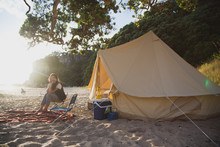 A Young Woman Camping On A New Zealand Beach