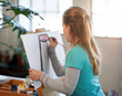 © Daxiao Productions/Stocksy - Creative young girl painting on easel