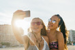 © MyMicrostock/Stocksy - Teen girls having fun at the beach while taking a selfie