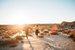 © PAULA G. FURI?/Stocksy - Young couple running in middle of the dessert